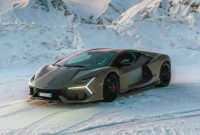 Lamborghini Revuelto berpose gagah di tengah hamparan salju pegunungan, menampilkan desain aerodinamis dengan lampu LED berbentuk Y yang khas.