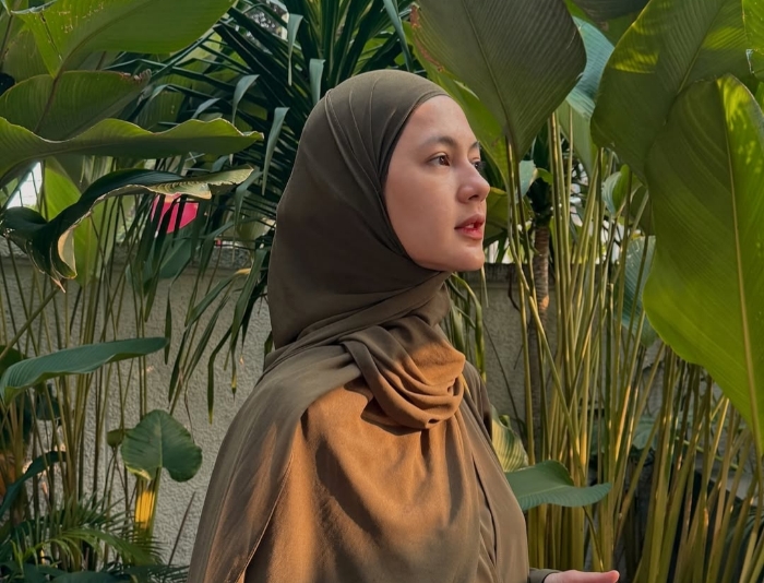 Paula Verhoeven tampil anggun dengan balutan hijab cokelat, memancarkan ketenangan di tengah hijaunya dedaunan tropis.(Foto: instagram/@paula_verhoeven)