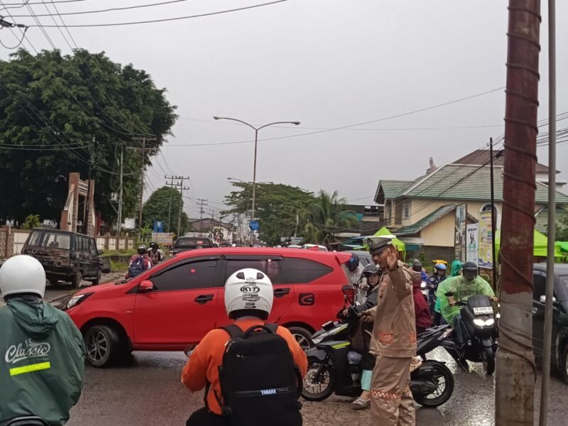 Hujan Tak Halangi Polantas Polres Melawi Atur Lalu Lintas Demi Keselamatan Pengguna Jalan
