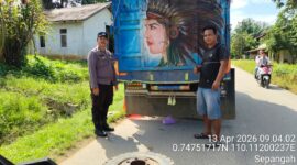 Aksi Sigap Polisi: Temani Sopir Truk Sawit Ganti Ban di Terik Matahari