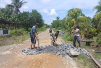 Babinsa Desa Ratu Sepudak dan Warga Gotong Royong Timbun Jalan Berlubang di Sambas