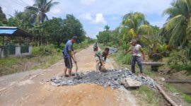 Babinsa Desa Ratu Sepudak dan Warga Gotong Royong Timbun Jalan Berlubang di Sambas
